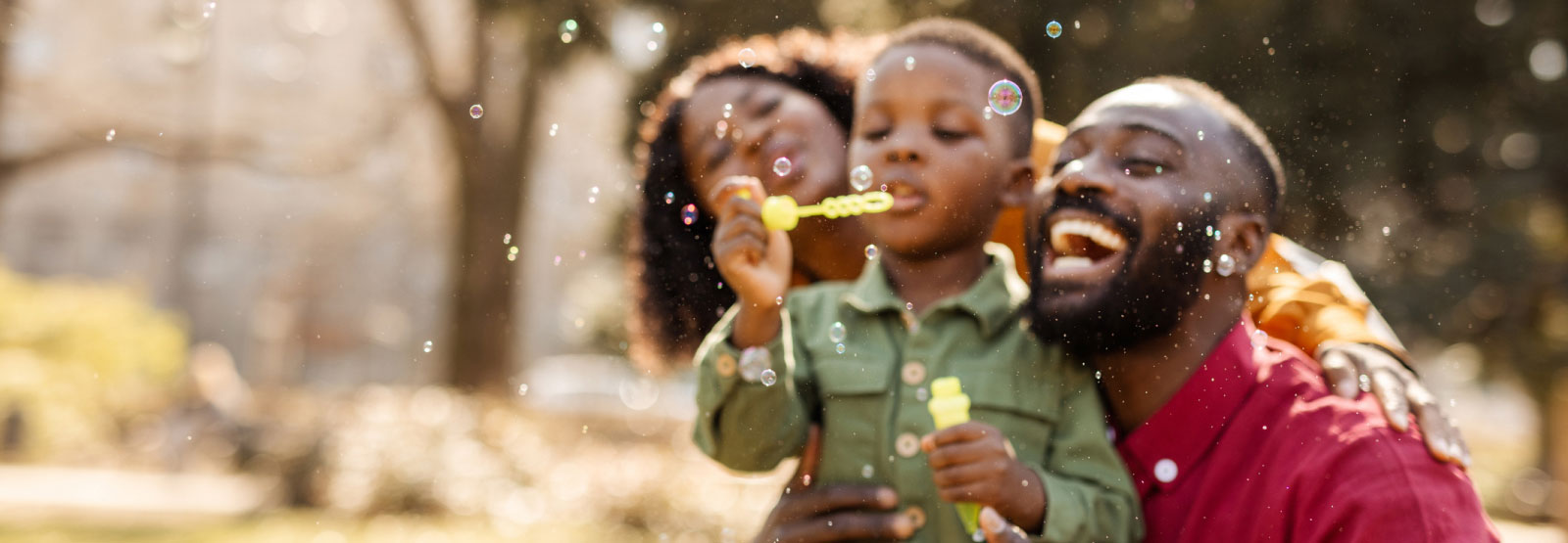 a family of three playing with bubbles
